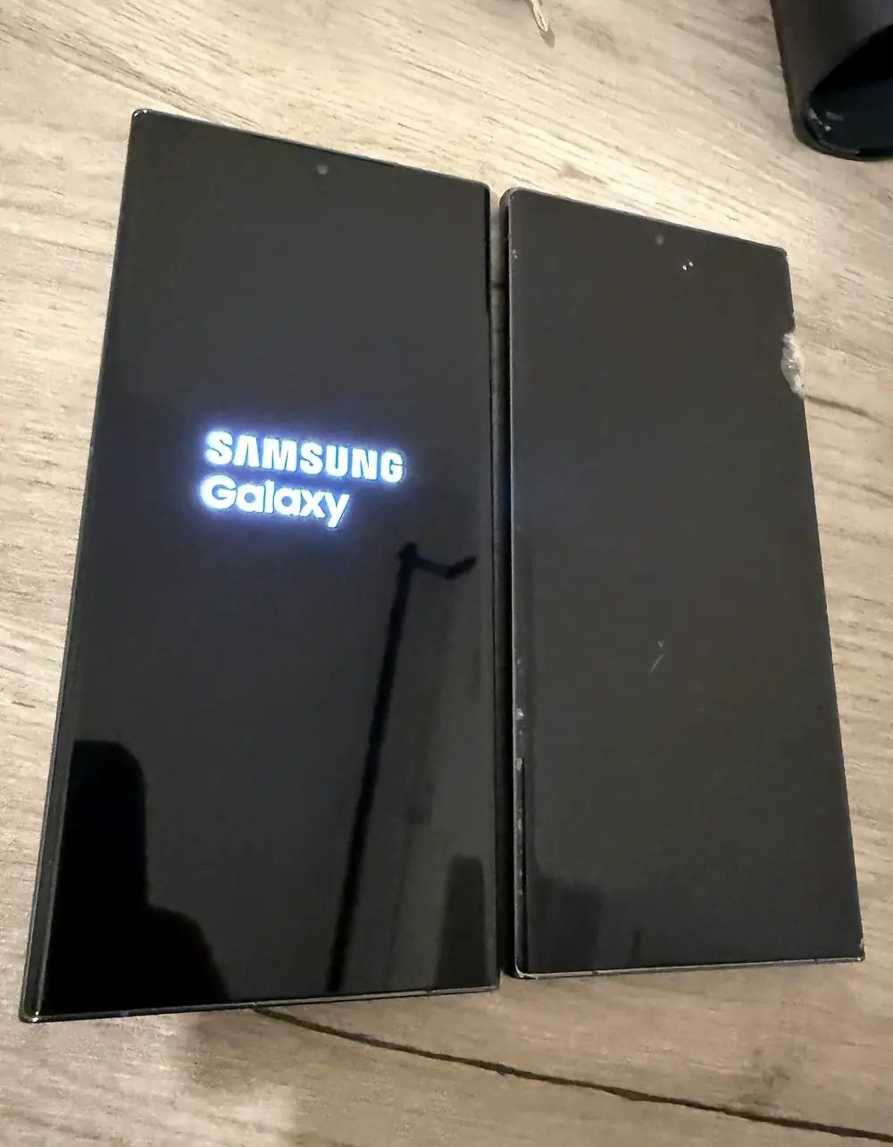 Samsung Galaxy S23 Ultra showing its boot screen beside the removed display